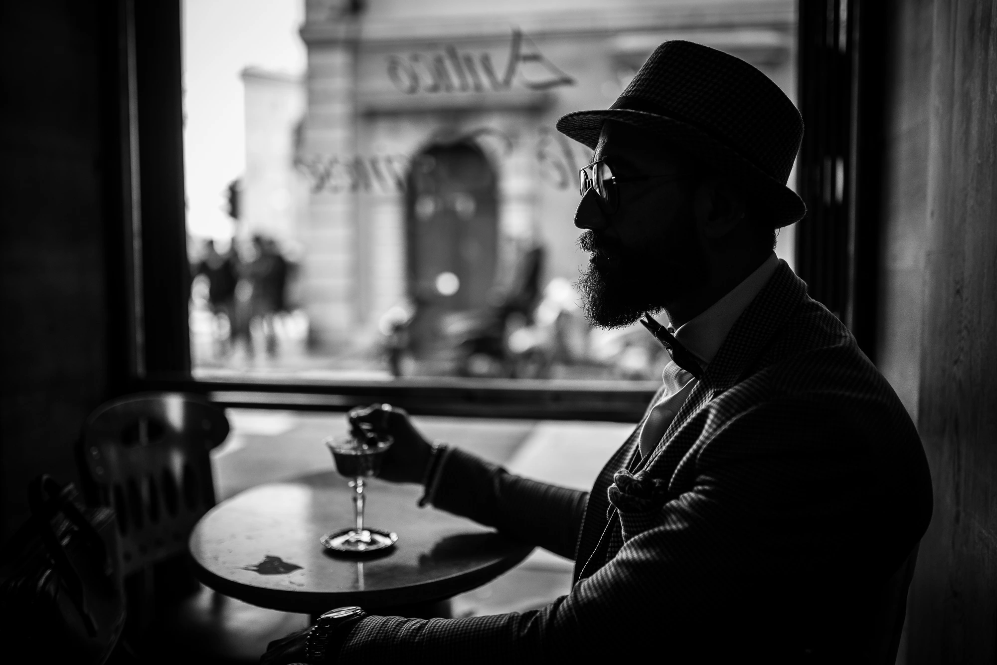 Man with hat at coffee shop, backlight