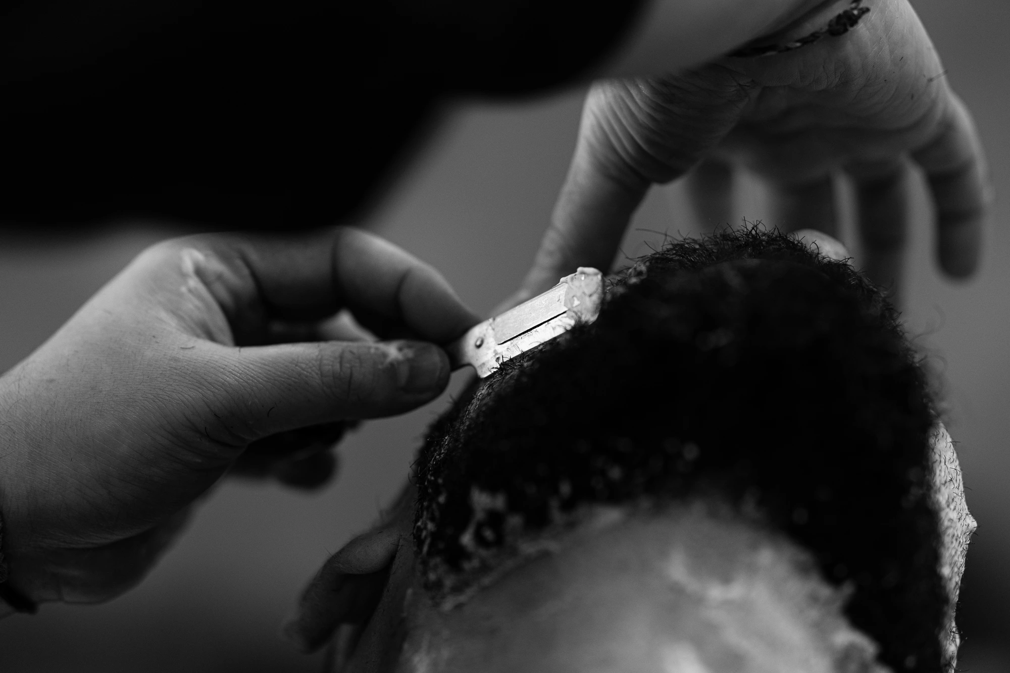 Knife razor trimming curly hair, dark background