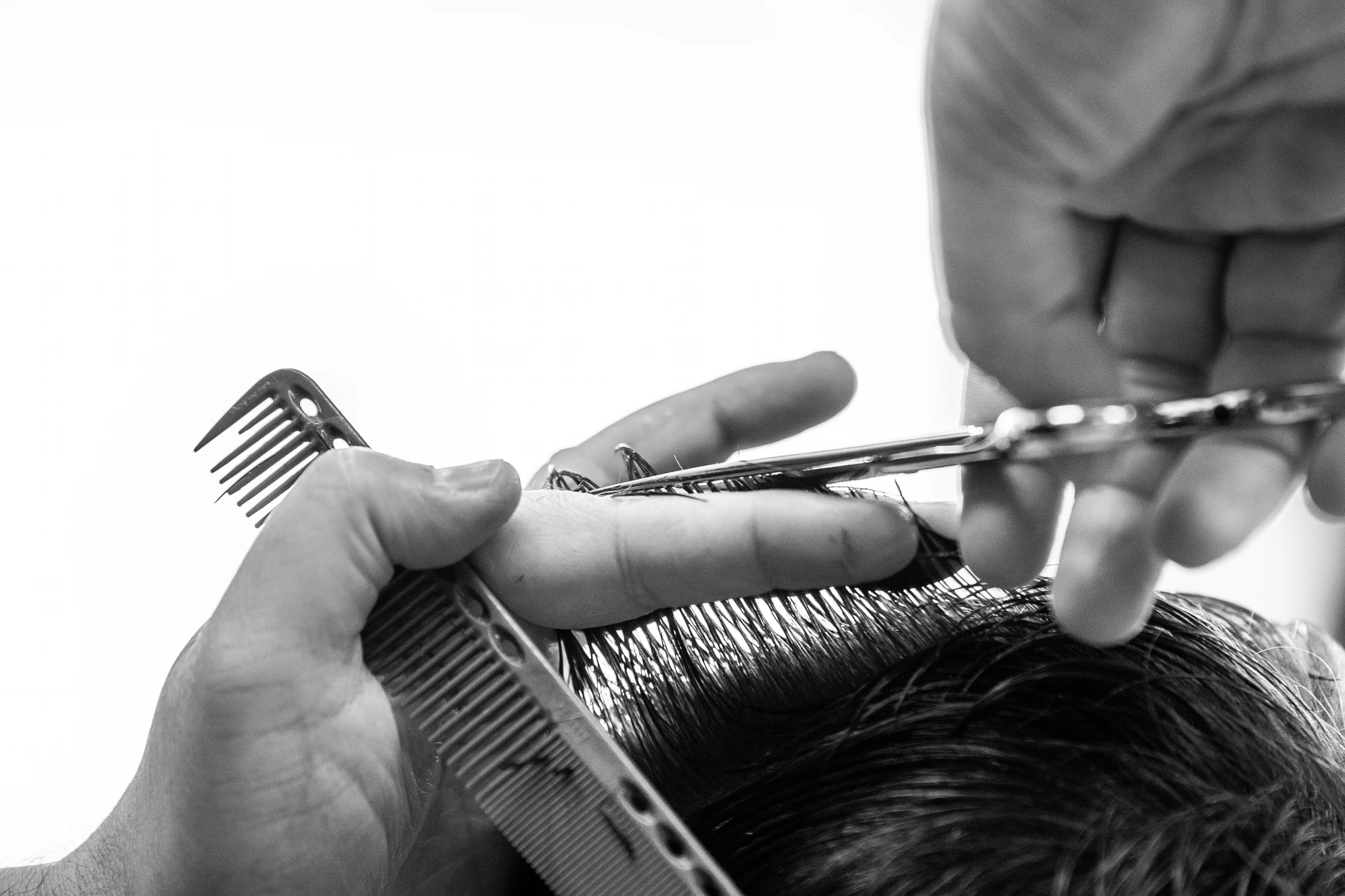 Scissors and wide comb cutting against the light