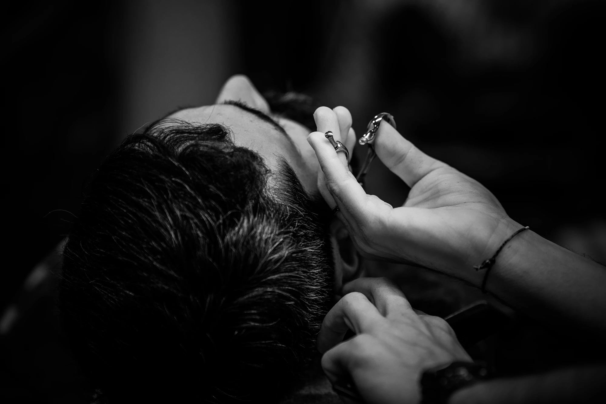 Hand with ring finishing behind ear, eyes closed