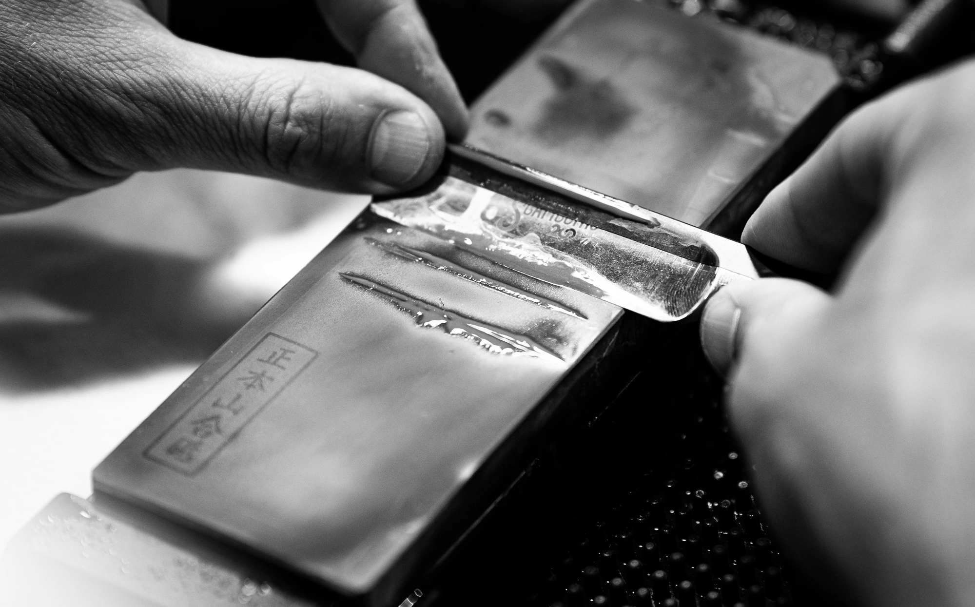 Sharpening a razor on a wet Japanese stone
